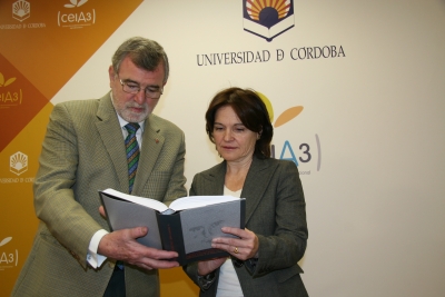 El rector y Celia Fernández hojean uno de los volúmenes antes de la presentación