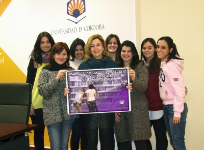 En el centro, la directora de la Unidad de Igualdad, Rosario Mrida, con mujeres universitarias y cartel conmemorativo del 8-M