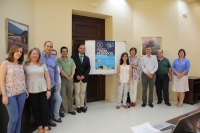 El vicerrector de Innovación y Transferencia, Enrique Quesada (el sexto por la izquierda), junto a los demás integrantes de la Comisión, junto al cartel anunciador del premio 