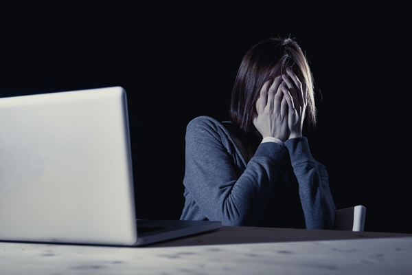 Una adolescente refleja una situación de acoso delante de un ordenador.