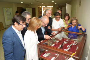 La responsable de la biblioteca del centro guía al rector, decano y otras autoridades durante su visita a la exposición.