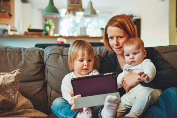 Mujer usando tablet con sus hijos (Unsplash)