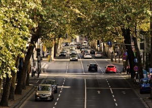 Varios coches circulan en la avenida de una ciudad. 